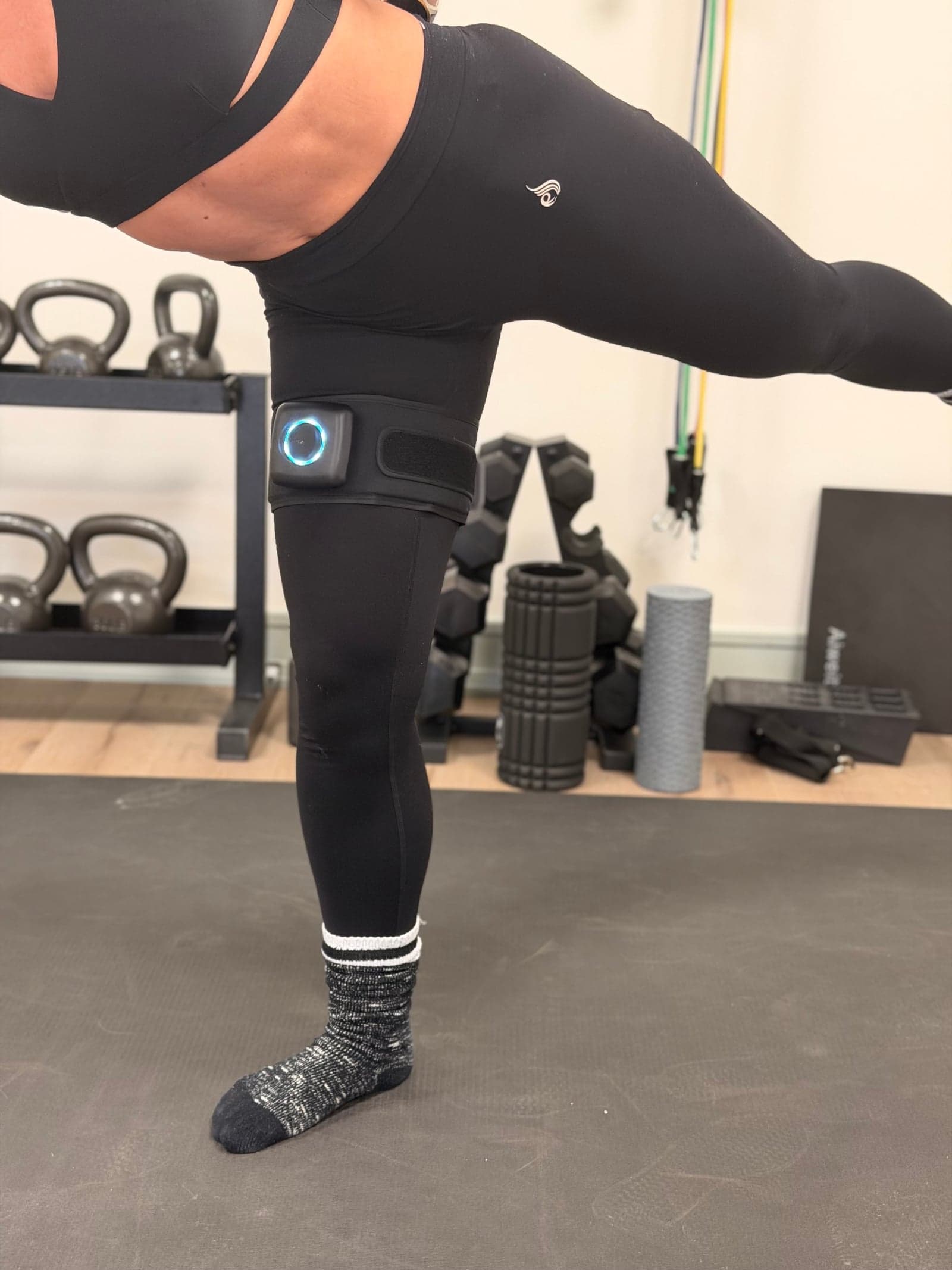 Single-leg balance exercise wearing a SAGA BFR cuff on the upper thigh during injury recovery at Thera Performance Lab in Lake Orion, Michigan