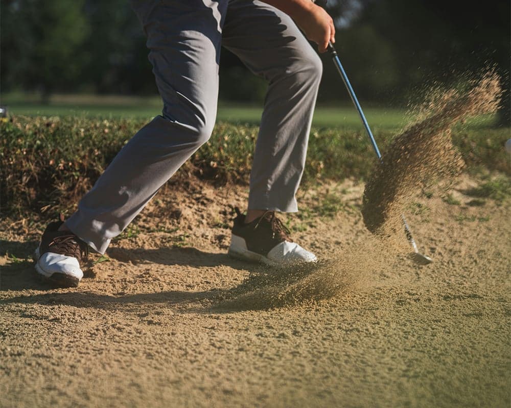 Golfer in a sand bunker. Robotic physical therapy for golf injuries at Thera Performance Lab in Lake Orion, MI