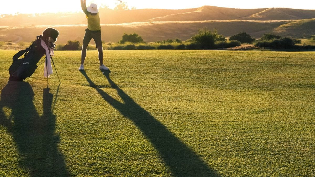 Golfer finishing his swing after recovering from low back pain with robotic therapy and TPI-guided rehab.